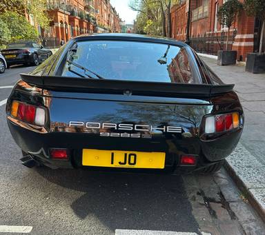 UK Number Plate 1 JO on a 1985 Black Porsche 928 S