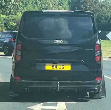 UK Number Plate 84 JG on a 2024 Black Ford Transit Custom 320lmtd Eblue A